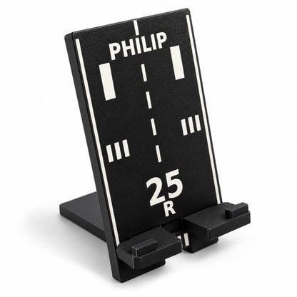 Black personalized runway phone stand showing 25R and PHILIP, angled view